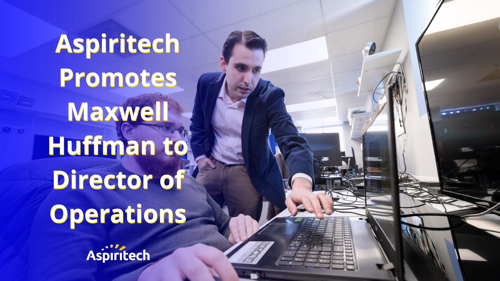 Text on the lefthand side reads, "Aspiritech Promotes Maxwell Huffman to Director of Operations" over an image of Maxwell standing by a seated peer. Maxwell points to keys on the laptop in front of his peer.