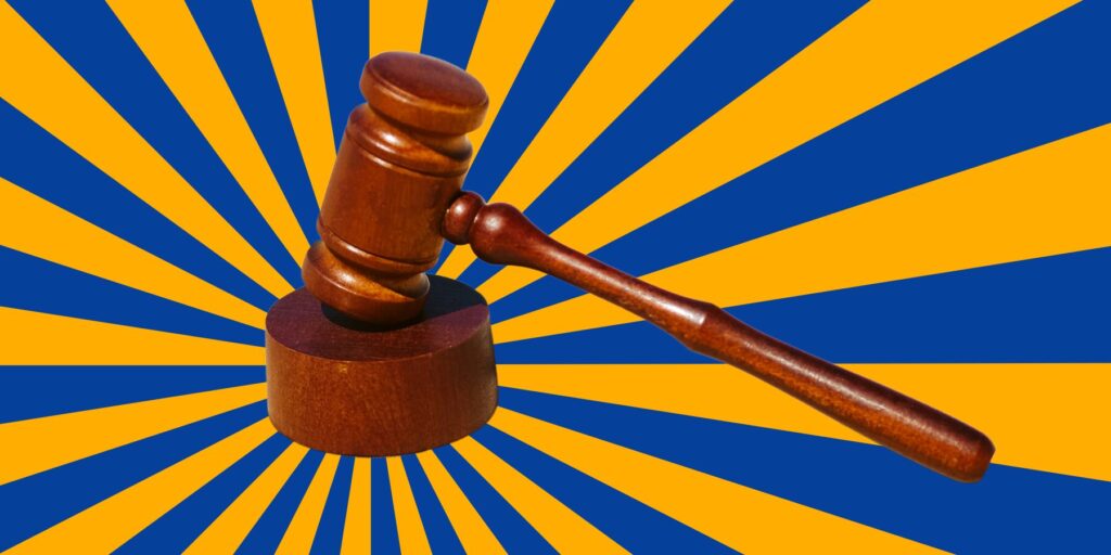 A gavel against a blue and orange burst background.