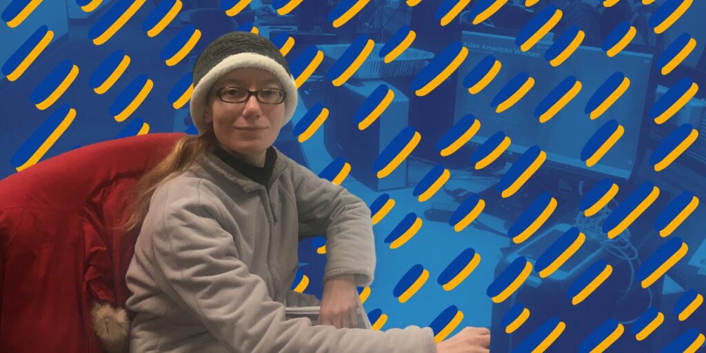 Julie Opalinski sits at a desk against a graphic blue and yellow background.