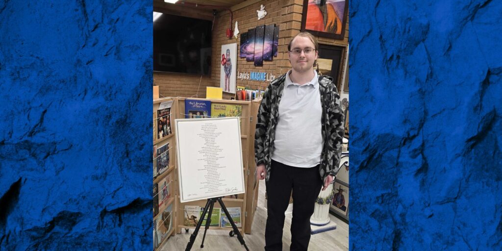 Eitan Sacks stands beside a print of his poem inside the International Servant Leaders Museum.