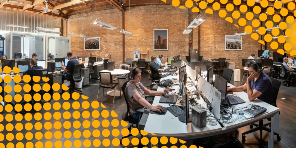 Employees work at long desks in the Aspiritech office in Evanston, Illinois.