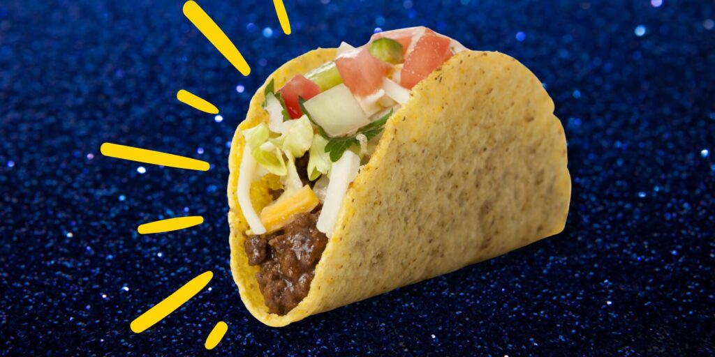 A hard tortilla taco on a glittering blue background with yellow graphic rays.