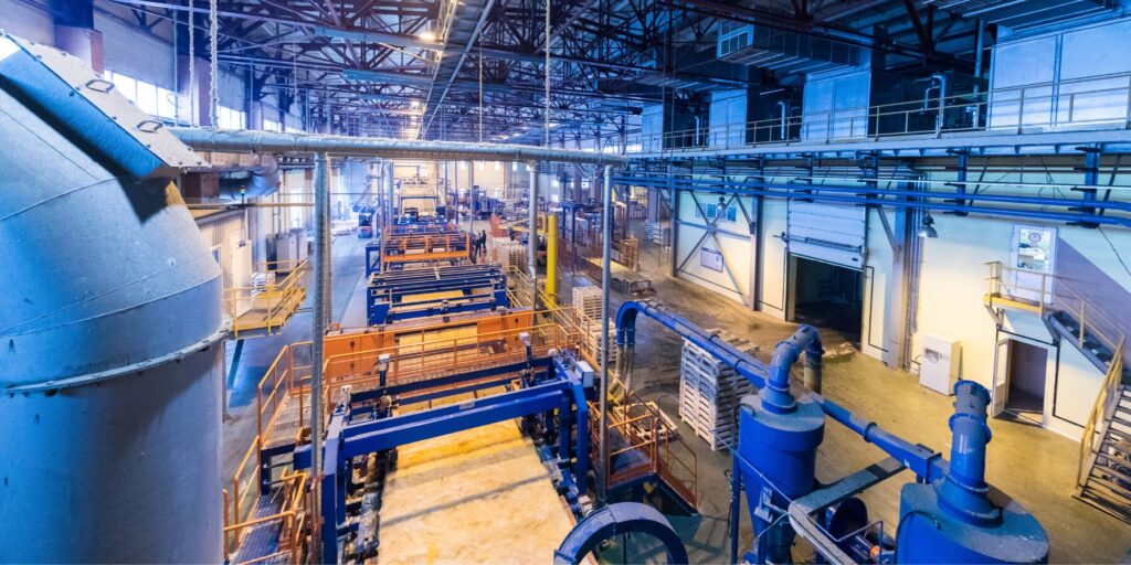 Top view of a modern operational plant producing fiberglass with heavy machinery.