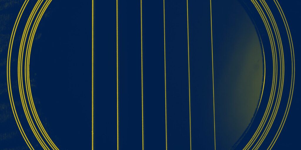 A guitar's sound hole with six strings.